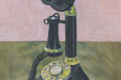 Black rotary candle stick-style telephone with a brass rotary dial.