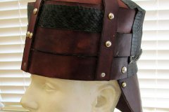 A triple-piece leather helmet fastened by silver metal studs.