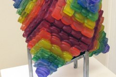 A multi-colored glass sculpture reminiscent of a terraced spinning top.