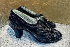 A pair of 1920s black shoes with a metallic gold metallic background.
