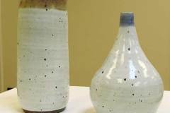 Two white speckled pieces of pottery - one cylindrical the other teardrop shaped.