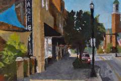 13 – Acrylic painting by J Bowers of a street scene focusing on the sign for a hardware store.