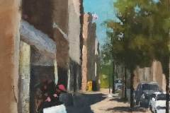 18 – Acrylic painting by J Bowers of a shadowy street scene on a sunny day on Gastonia's Main Street.