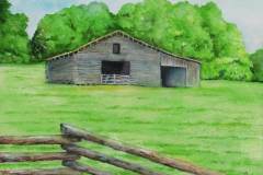 50 an old still functioning grey barn in a green field.