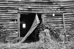 Ancient barn with a door fallen off its hinges.