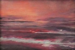 Rose sunset on waves hitting shoreline.