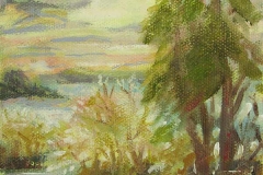 Small seated person viewing trees and lake under a pastel colored sky.