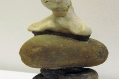 69, a 3D model/sculpture (viewed from the front) of a realistic sorrowful head and shoulders of a figure sitting on 3 stacked semi-smooth rocks.