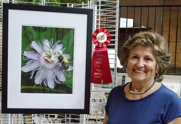 Shirley Brutko nect to her photo of flower and bee