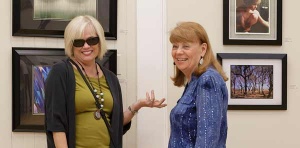 Cam Tracy and Linda Pellerin conversing on front of work from the 2019 Nature Reconsidered and Trail exhibit.