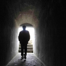 Photograph of man in dark tunnel by Alex Pietersen.