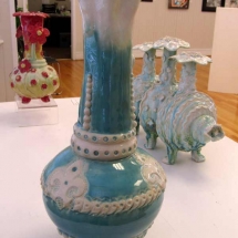 aqua marine colored vase with white fleur-de-lis decorations and scallops by artist Renee Matthews.