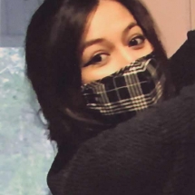 Photograph of dark haired woman in a plaid mask by Patricia Pietersen.