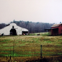 Appalachian white barn and red lean-to photographed in color by photographer Robert Webb.