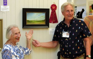 Artist Michale Phillip and his mother in front of his second place winning oil painting “Fall Harvest”.