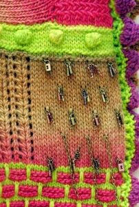 Detail of multi-colored shawl with metal charms by artist Beverly Sandararamen.