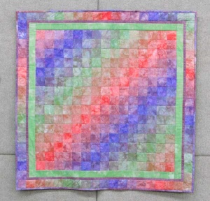 Multi-colored pixel gradient quilt by artist Carol Mclaughlin.