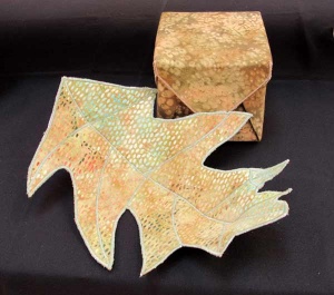 Leaf-shaped quilted fabric sculpture with matching fabric box by artist Carol Mclaughlin.