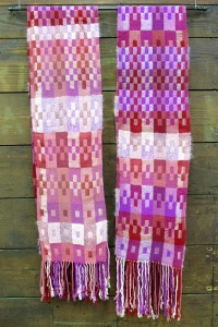 Woven pink and magenta striped and box-shaped designs on 2 scarves with fringe by artist Chris Dunlap.