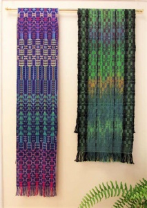 2 knitted scarves with geometric designs - one with magenta to blue by artist Sallie Olson, another green to black by artist Linda Erickson.