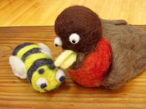 Felted wool sculptures of a bumble bee and bird by artist Stephanie Ray.