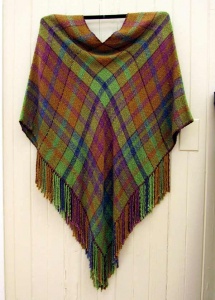 Green, russett, and blue plaid shawl with fringe woven by artist Sue Helmken.