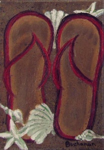 Two flip flop shoes on a beach.