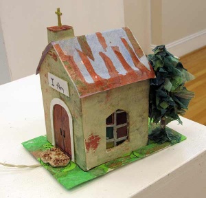 Sculpture of tree and rural church with sign stating I Am.