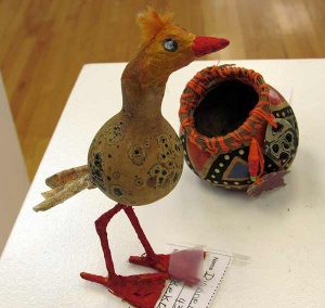 Colorful gourd sculpture of bird and nest.