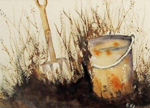 Pitchfork planted in the ground next to a garden pail.