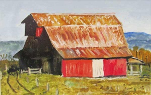 Red barn with rusted metal roof in a rural setting with mountains in the background.