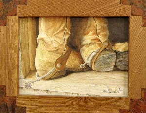 Feet-level view of spurred cowboy boots in a rustic wood frame.