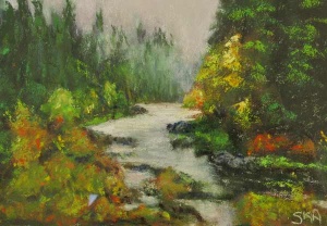 Mountain stream running through pine trees and spots of red blooms.