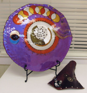 A purple and patterned shield and a leather arm armor.