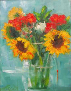 Sunflowers and red flowers in a glass vase against a light blue background.