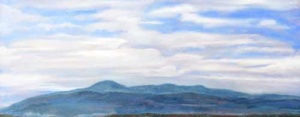 wide horizontal view of blue ridge mountains under a blue cloudy sky.