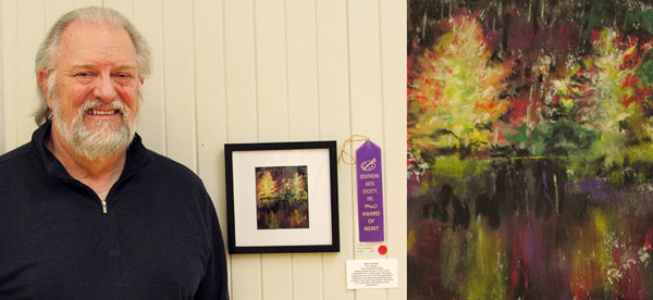 Ron Shepard with purple ribbon and his merit award-winning pastel rendering of colorful trees reflected in water titled Faux Cristmas.