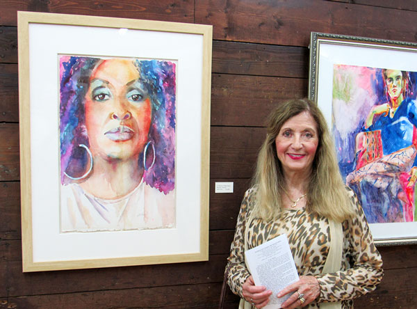 Artist Barbara ONeal Davis with her watercolor of an african american woman with hoop earrings rendered in purple and magenta.