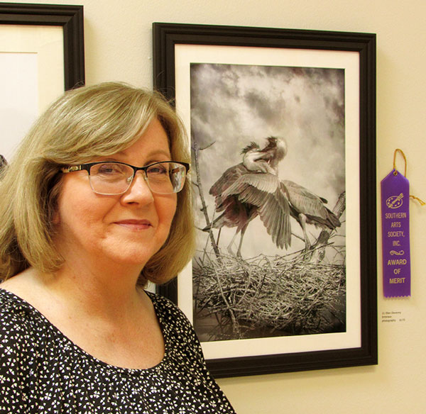 Photographer Ellen Devenney with her black and white photo of 2 birds embracing.