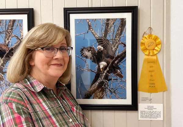 Photographer Ellen Devenney with her color photograph of two eagles in a tree.