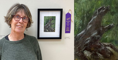 Artist Susan Arrowood with her pastel drawing of a gnarled tree stump.