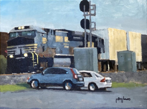 Two cars waiting for the train to pass the city street crossing.