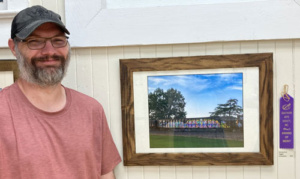 Photographer Jerry Pruitt with his merit award color photo of a stopped train with colorful graffiti.