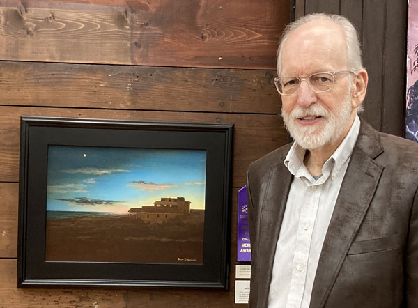 Artist Gene Tennison with his artwork.