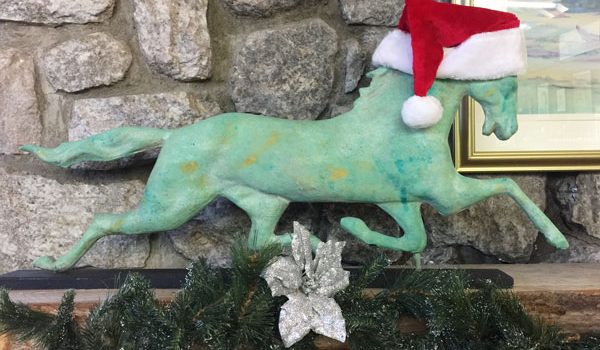 horse sculpture with green patina with a santa hat