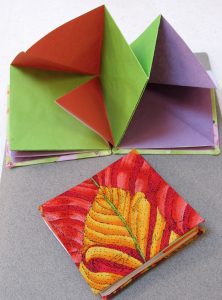 red and yellow covered art book with purple, red, and green folded interior pages by Bill Mason